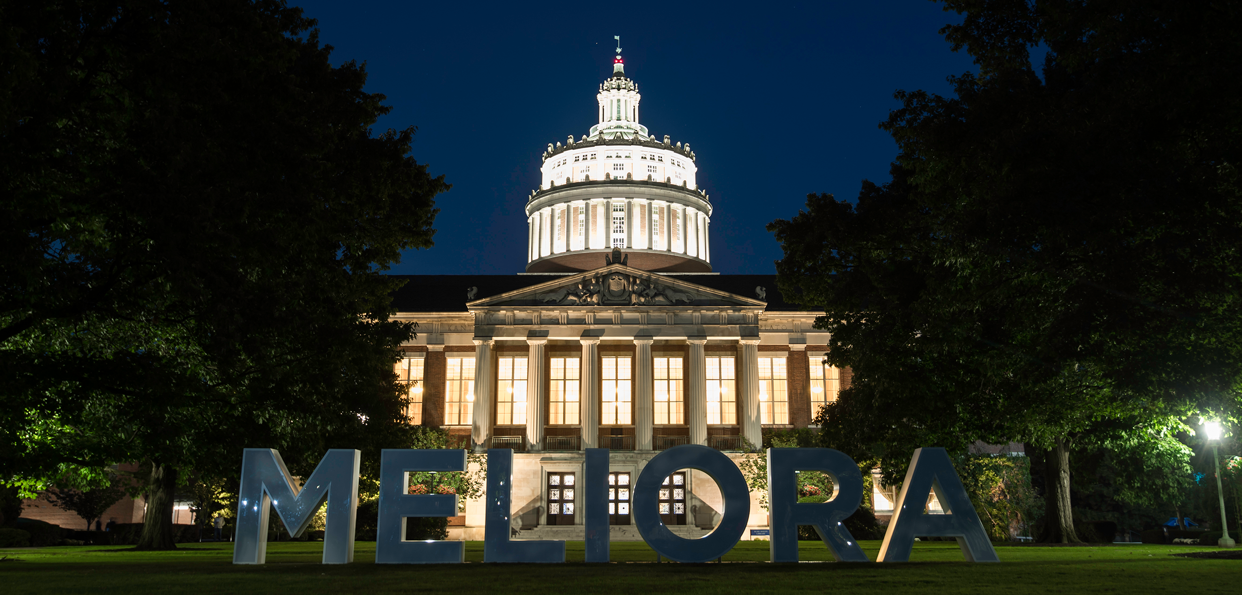 Rush Rhees library at night with Meliora across the quad