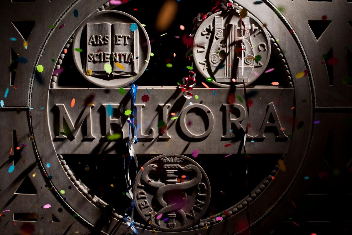 Confetti rains in front of marble Meliora panel in Hawkins Carlson room 