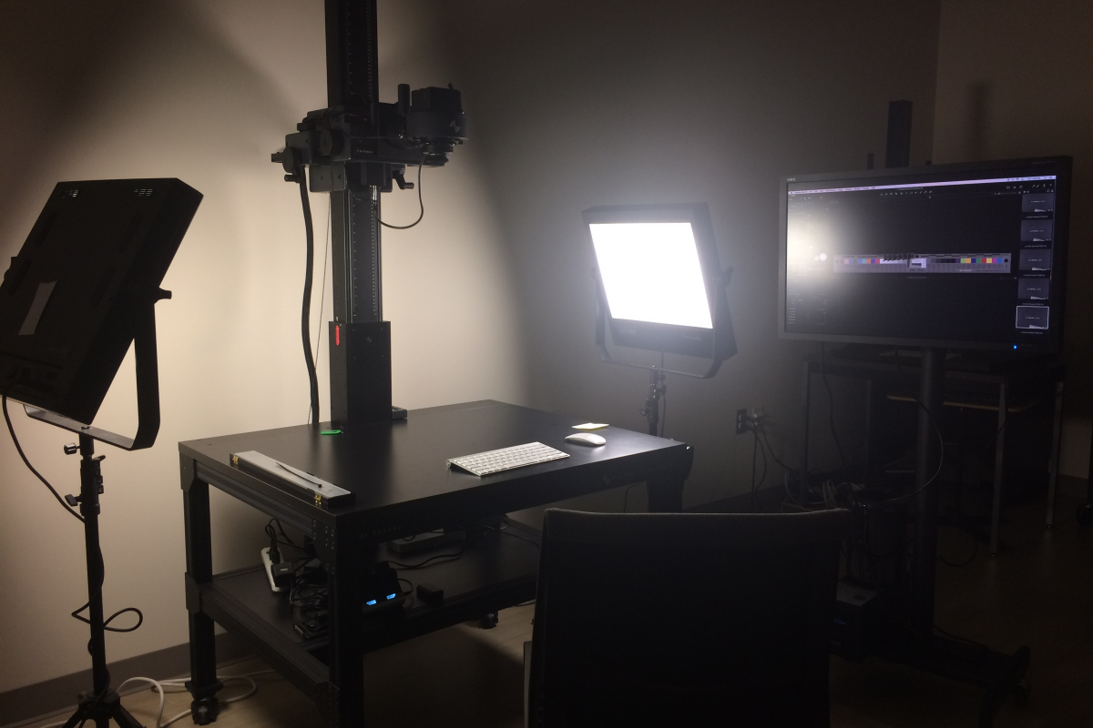 Large flat bed table with camera positioned above it and two industry standard lights on either side of the table.