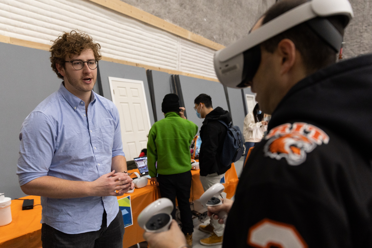 Karp fellow helps a fellow student with using the VR headset. Photo by Quinn Freidenburg