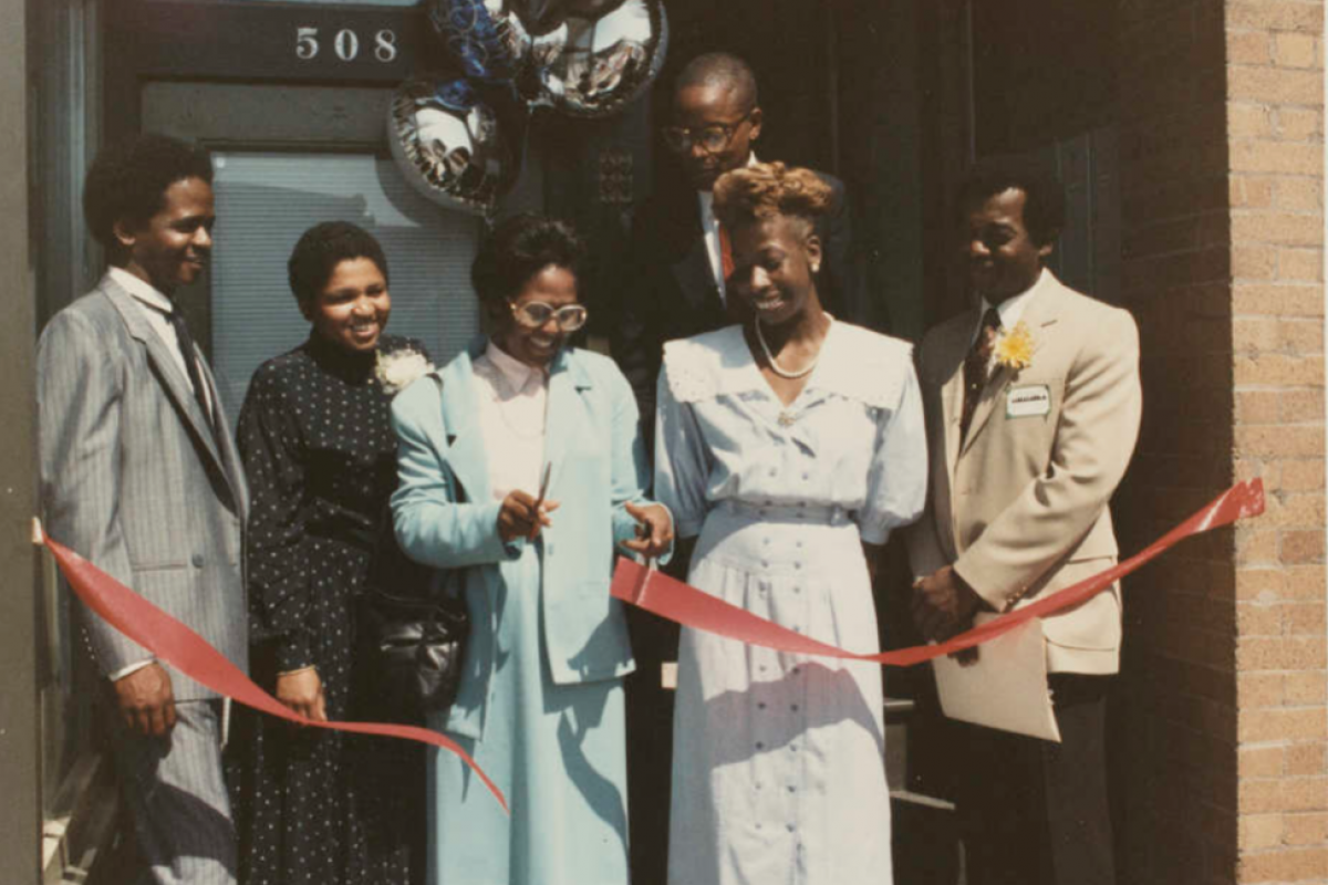 Ruth Scott cutting a ribbon for a ribbon cutting event for West Main Street Alliance