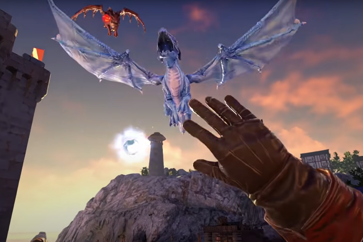 A gloved hand reaches for a blue dragon near a medieval tower at sunset.