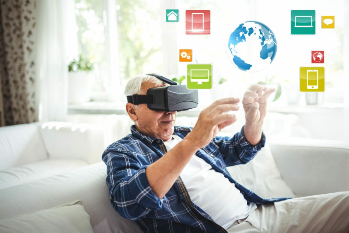 An elderly man with a VR headset sits beside a nurse.