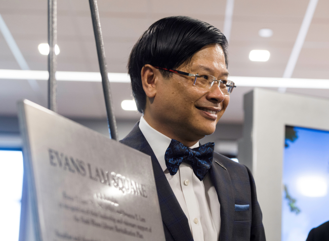 Evans Lam next to a plaque for Lam Square