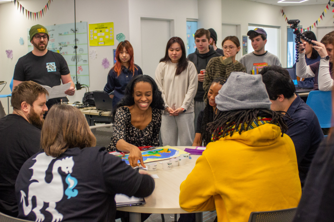 students playing their board game for the judges. 