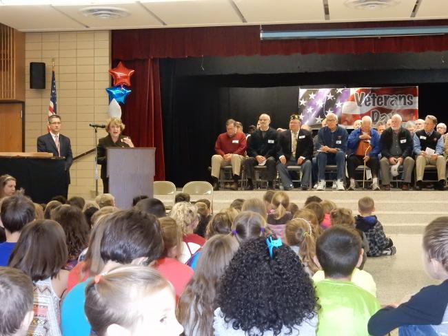 With war veterans behind her Congresswoman Louise Slaughter speaks to an assembly of elementary school kids