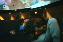 students smiling and looking at films on the dome
