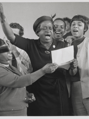 Photo of group of people, with person reading from a paper they is holding