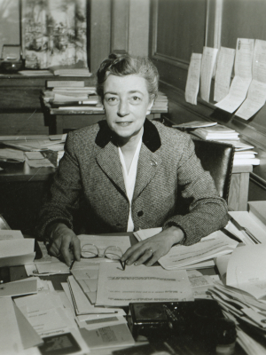 Photograph of Koller seated with hand on a document
